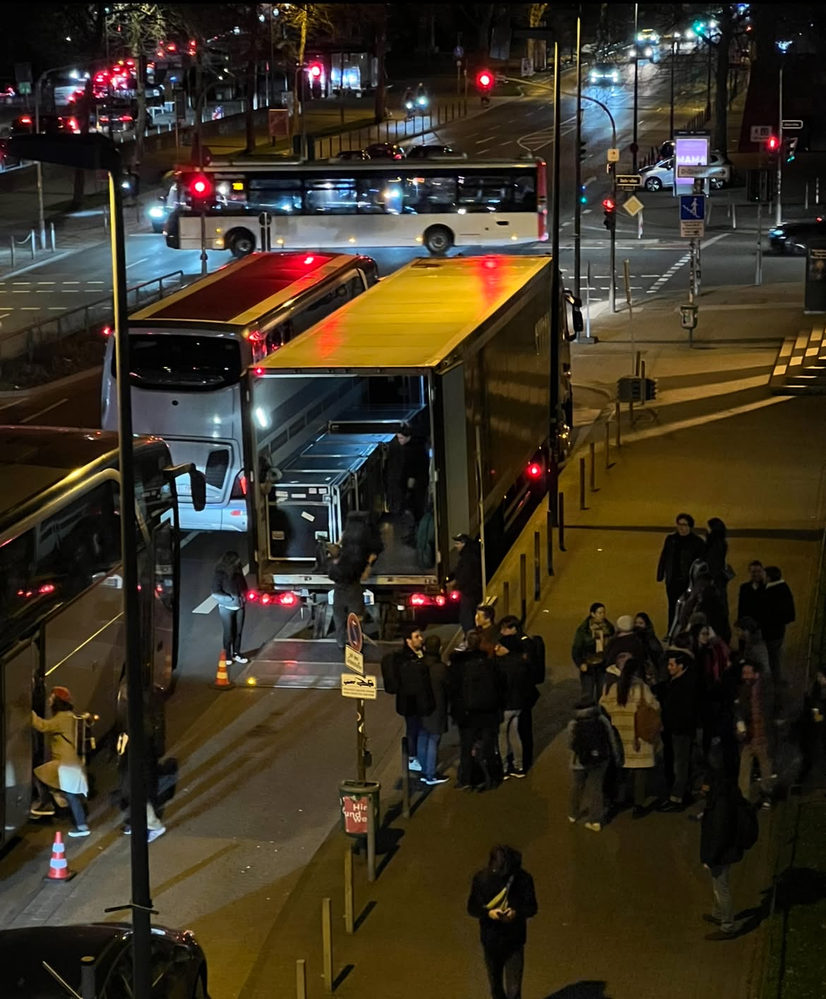 Bird's-eye view of tour truck unloading instruments at night